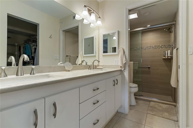 5705 Ashton Way Unit 5705, Sarasota, FL 34231 - bathroom featuring double vanity, a shower stall, a walk in closet, and tile patterned floors