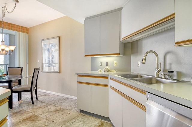 1211 Gulf Of Mexico Dr Unit 105, Longboat Key, FL 34228 - kitchen with stainless steel dishwasher, light countertops, light marble finish flooring, and a chandelier