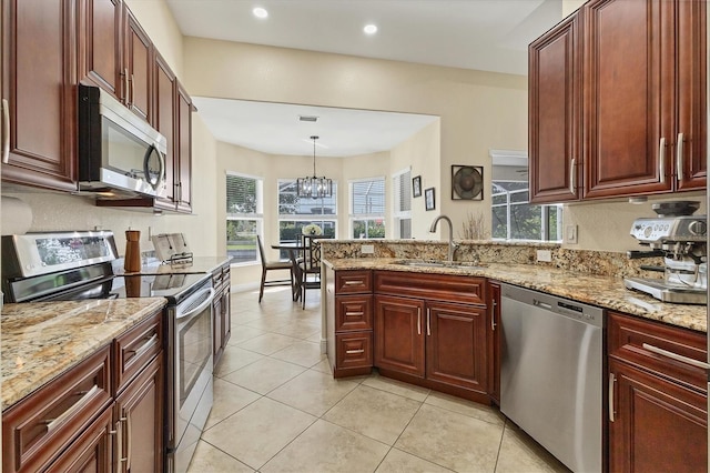 1402 SW 4th Ln, Cape Coral, FL 33991 - kitchen with appliances with stainless steel finishes, healthy amount of natural light, a peninsula, light stone counters, and recessed lighting
