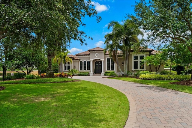 6926 Lacantera Cir, Lakewood Ranch, FL 34202 - mediterranean / spanish-style home featuring stucco siding, a front yard, curved driveway, and a tiled roof