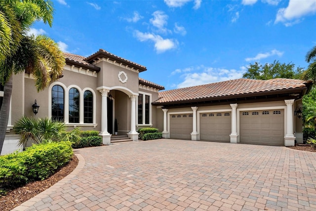 6926 Lacantera Cir, Lakewood Ranch, FL 34202 - mediterranean / spanish house featuring decorative driveway, an attached garage, stucco siding, and a tile roof