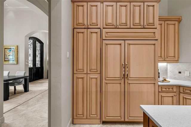 6926 Lacantera Cir, Lakewood Ranch, FL 34202 - kitchen featuring arched walkways, light countertops, decorative backsplash, and ornamental molding