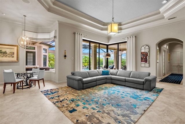 6926 Lacantera Cir, Lakewood Ranch, FL 34202 - tiled living room with arched walkways, crown molding, a tray ceiling, a chandelier, and a textured ceiling