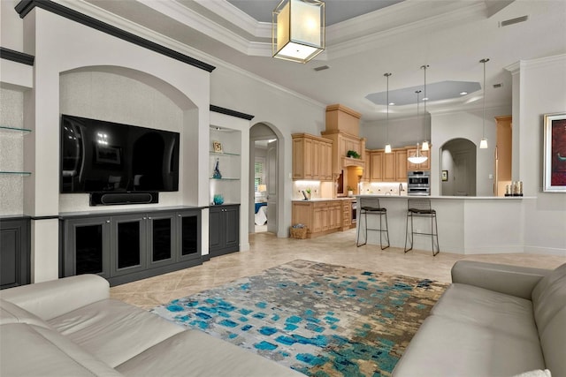 6926 Lacantera Cir, Lakewood Ranch, FL 34202 - living room with a tray ceiling, ornamental molding, built in shelves, arched walkways, and recessed lighting