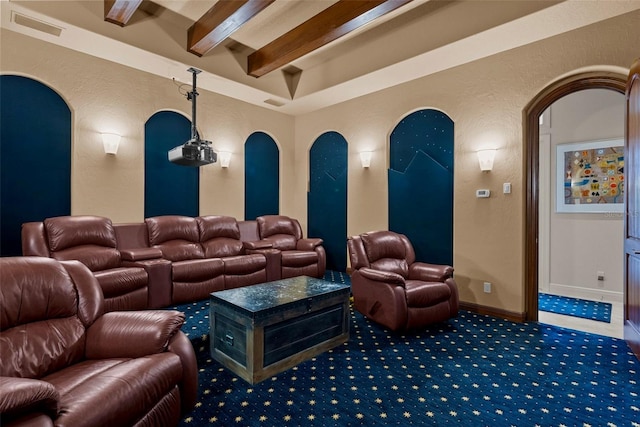 6926 Lacantera Cir, Lakewood Ranch, FL 34202 - carpeted cinema room with beamed ceiling, a textured wall, and arched walkways