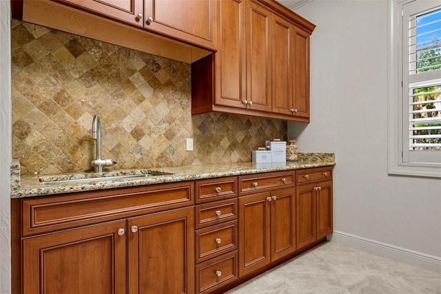 6926 Lacantera Cir, Lakewood Ranch, FL 34202 - kitchen featuring decorative backsplash, brown cabinetry, light stone countertops, and light tile patterned floors