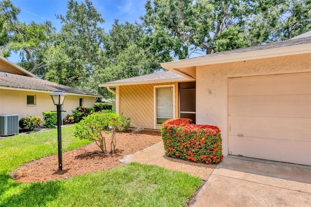 3557 Wilkinson Woods Dr, Sarasota, FL 34231 - property entrance with a lawn, a garage, and stucco siding