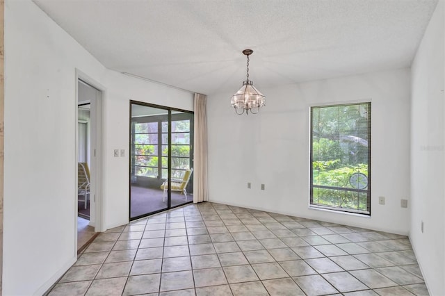 3557 Wilkinson Woods Dr, Sarasota, FL 34231 - empty room featuring a chandelier, light tile patterned floors, and a textured ceiling