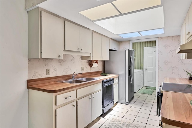 3557 Wilkinson Woods Dr, Sarasota, FL 34231 - kitchen featuring washer and clothes dryer, wallpapered walls, black dishwasher, a skylight, and light tile patterned floors