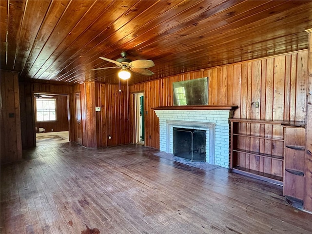 1109 Patterson Dr, Sarasota, FL 34234 - unfurnished living room with wood ceiling, wooden walls, hardwood / wood-style flooring, a brick fireplace, and ceiling fan