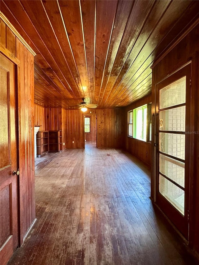 1109 Patterson Dr, Sarasota, FL 34234 - spare room with dark wood-type flooring, wooden ceiling, plenty of natural light, wood walls, and a ceiling fan