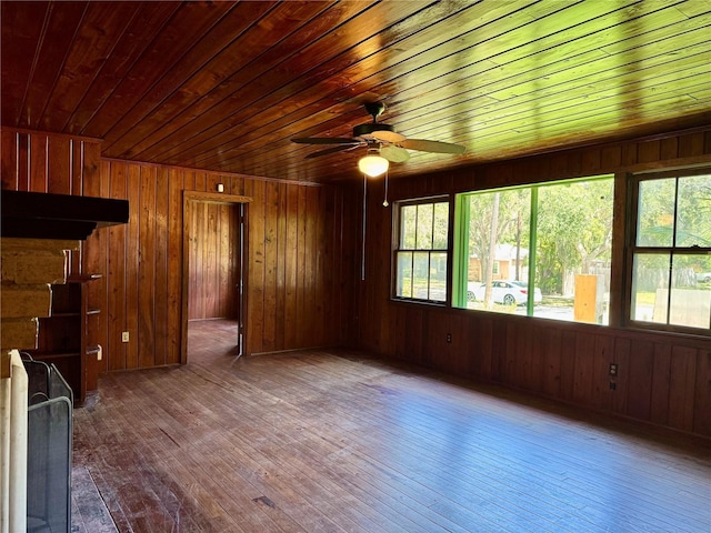 1109 Patterson Dr, Sarasota, FL 34234 - unfurnished living room with wooden ceiling, hardwood / wood-style flooring, ceiling fan, and wood walls