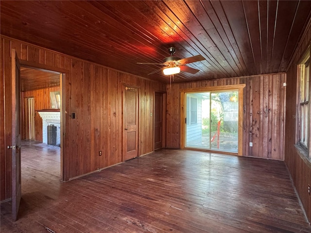 1109 Patterson Dr, Sarasota, FL 34234 - unfurnished room with wood walls, a brick fireplace, wood-type flooring, wooden ceiling, and ceiling fan