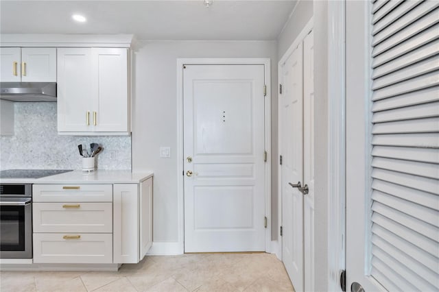 750 N Tamiami Trl Unit 1616, Sarasota, FL 34236 - kitchen with oven, under cabinet range hood, light tile patterned flooring, light countertops, and black electric stovetop