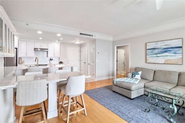 750 N Tamiami Trl Unit 1616, Sarasota, FL 34236 - living area featuring light wood finished floors, crown molding, and recessed lighting