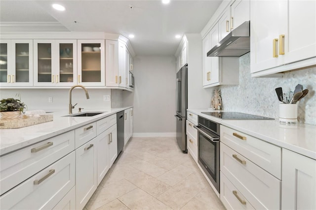 750 N Tamiami Trl Unit 1616, Sarasota, FL 34236 - kitchen with under cabinet range hood, appliances with stainless steel finishes, white cabinets, backsplash, and glass insert cabinets
