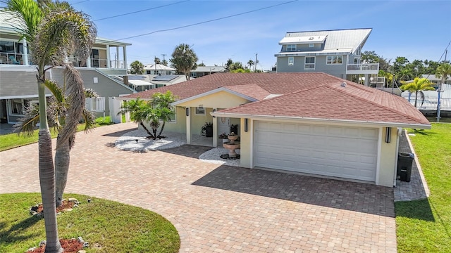 6917 22nd St W, Bradenton, FL 34207 - view of front of home with stucco siding, decorative driveway, a garage, and a shingled roof