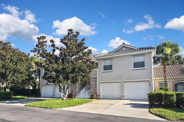 7605 Sweetbay Cir Unit 5-102, Bradenton, FL 34203 - view of front of home with a tile roof, driveway, a garage, and stucco siding