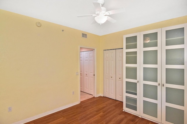 7605 Sweetbay Cir Unit 5-102, Bradenton, FL 34203 - unfurnished bedroom with wood finished floors, multiple closets, and ceiling fan