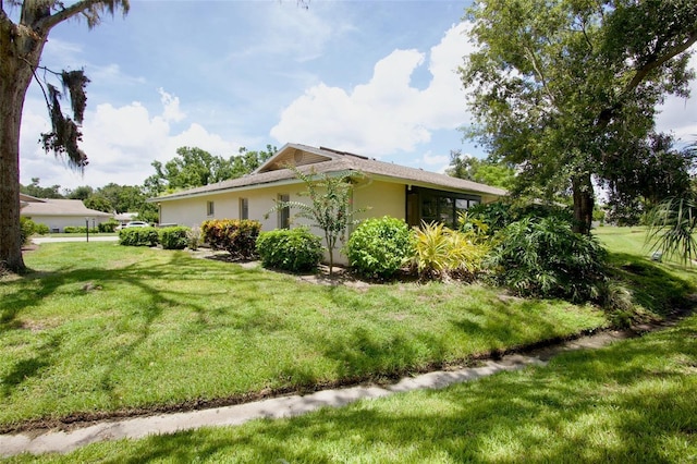3518 Wilkinson Woods Dr Unit 11, Sarasota, FL 34231 - view of home's exterior with a lawn and stucco siding