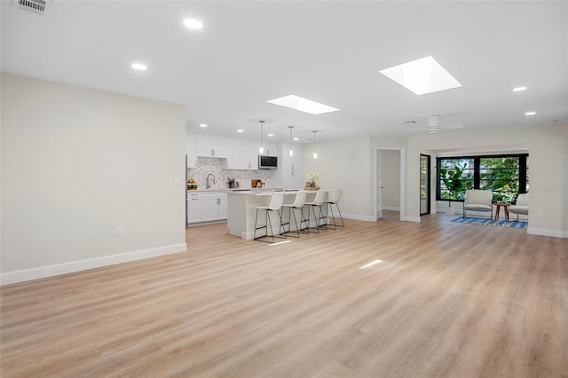 3518 Wilkinson Woods Dr Unit 11, Sarasota, FL 34231 - living room featuring a skylight, recessed lighting, and light wood-type flooring
