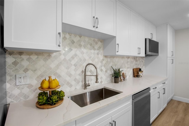 3518 Wilkinson Woods Dr Unit 11, Sarasota, FL 34231 - kitchen featuring dishwasher, white cabinets, light stone countertops, light wood-style floors, and decorative backsplash