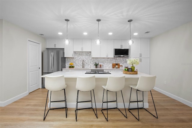 3518 Wilkinson Woods Dr Unit 11, Sarasota, FL 34231 - kitchen featuring white cabinetry, a kitchen bar, backsplash, a kitchen island, and recessed lighting
