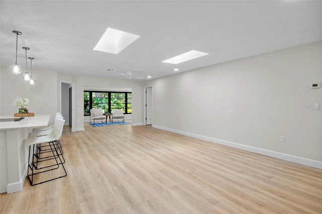 3518 Wilkinson Woods Dr Unit 11, Sarasota, FL 34231 - unfurnished living room featuring a skylight, light wood-style floors, and recessed lighting