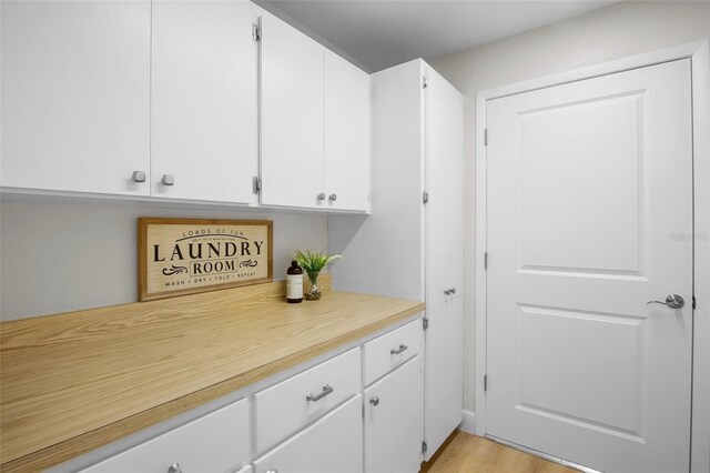 3518 Wilkinson Woods Dr Unit 11, Sarasota, FL 34231 - kitchen with light countertops, white cabinets, and light wood finished floors