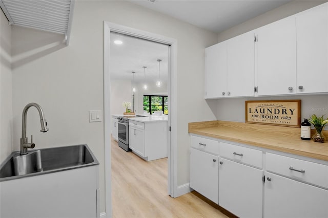 3518 Wilkinson Woods Dr Unit 11, Sarasota, FL 34231 - kitchen with stainless steel range with electric stovetop, light wood finished floors, white cabinetry, and light countertops