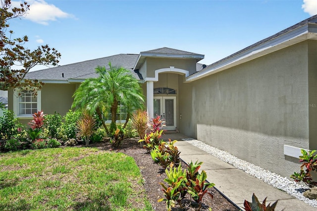 4668 73rd St E, Bradenton, FL 34203 - doorway to property featuring stucco siding, french doors, and a shingled roof