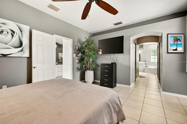 4668 73rd St E, Bradenton, FL 34203 - bedroom with arched walkways, light tile patterned floors, ensuite bathroom, and ceiling fan
