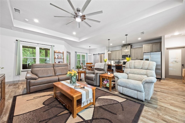 174 SW Caboose Dr, Fort White, FL 32038 - living room with a ceiling fan, a tray ceiling, recessed lighting, and light wood-style flooring