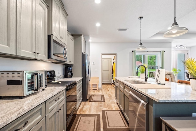 174 SW Caboose Dr, Fort White, FL 32038 - kitchen featuring stainless steel appliances, light wood-style floors, a kitchen island with sink, recessed lighting, and pendant lighting