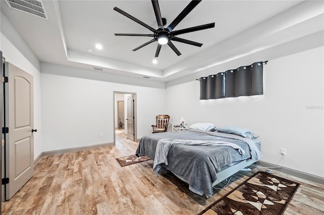 174 SW Caboose Dr, Fort White, FL 32038 - bedroom with recessed lighting, light wood-style floors, a tray ceiling, ensuite bathroom, and a ceiling fan