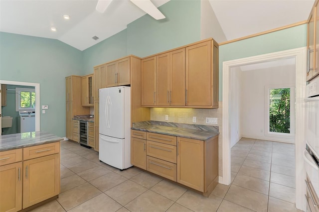 1236 Port Ln, Sarasota, FL 34242 - kitchen featuring freestanding refrigerator, light tile patterned floors, decorative backsplash, high vaulted ceiling, and light brown cabinets