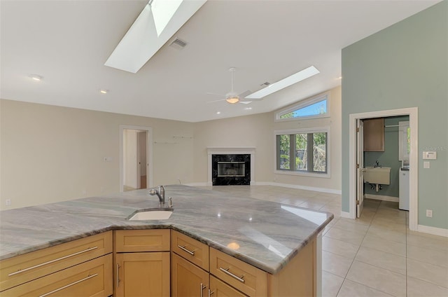 1236 Port Ln, Sarasota, FL 34242 - kitchen with a skylight, light tile patterned flooring, a high end fireplace, light stone counters, and vaulted ceiling