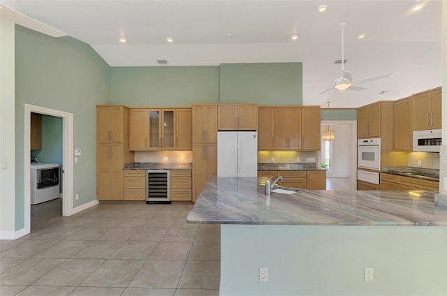 1236 Port Ln, Sarasota, FL 34242 - kitchen with white appliances, high vaulted ceiling, beverage cooler, washer / dryer, and a warming drawer