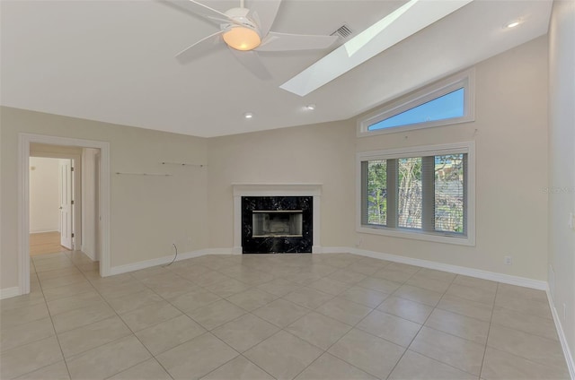 1236 Port Ln, Sarasota, FL 34242 - unfurnished living room featuring light tile patterned flooring, a fireplace, lofted ceiling, ceiling fan, and a skylight