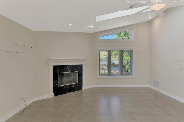 1236 Port Ln, Sarasota, FL 34242 - unfurnished living room featuring a high end fireplace, light tile patterned flooring, a ceiling fan, a skylight, and vaulted ceiling
