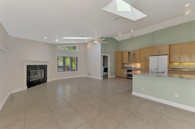 1236 Port Ln, Sarasota, FL 34242 - kitchen with freestanding refrigerator, a skylight, light tile patterned floors, open floor plan, and high vaulted ceiling