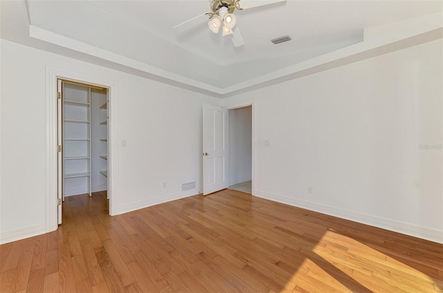 1236 Port Ln, Sarasota, FL 34242 - empty room featuring a raised ceiling, ceiling fan, and light wood-type flooring