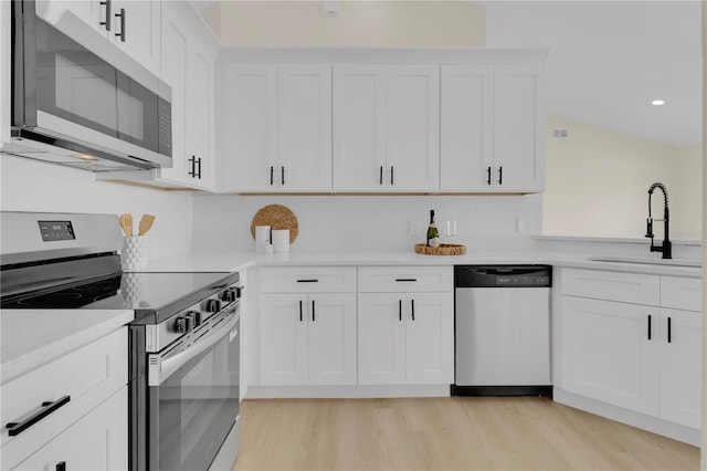1820 Putney Cir, Orlando, FL 32837 - kitchen with stainless steel appliances, light wood-style floors, light countertops, white cabinets, and recessed lighting
