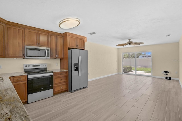 5830 Midnight Pass Rd Unit 108, Sarasota, FL 34242 - kitchen with appliances with stainless steel finishes, brown cabinetry, ceiling fan, and light wood finished floors