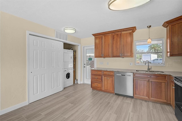 5830 Midnight Pass Rd Unit 108, Sarasota, FL 34242 - kitchen with stainless steel dishwasher, stacked washer / dryer, brown cabinets, light wood finished floors, and hanging light fixtures