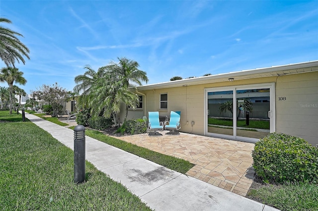 5830 Midnight Pass Rd Unit 108, Sarasota, FL 34242 - rear view of house featuring a yard and a patio area