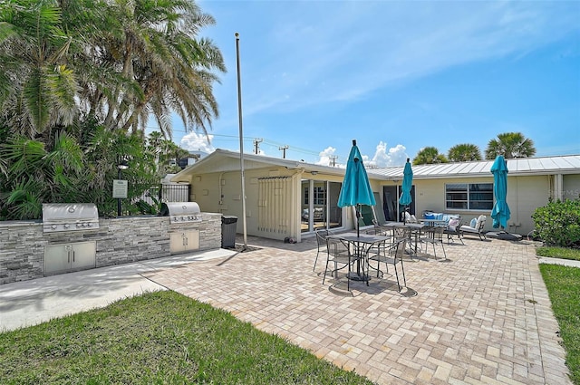 5830 Midnight Pass Rd Unit 108, Sarasota, FL 34242 - view of patio / terrace featuring exterior kitchen and outdoor dining space