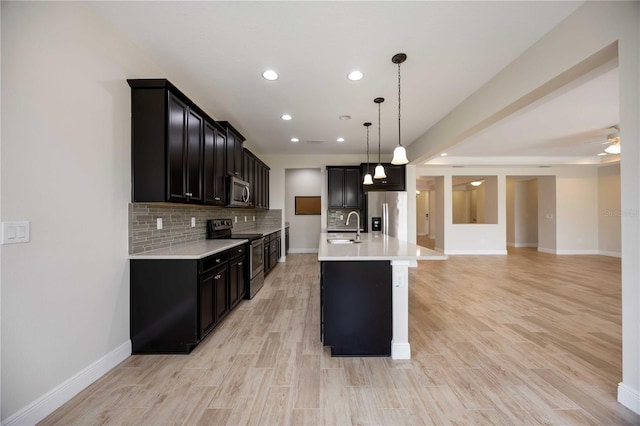 11680 Tapestry Ln, Venice, FL 34292 - kitchen featuring appliances with stainless steel finishes, dark cabinets, light countertops, recessed lighting, and light wood-style flooring