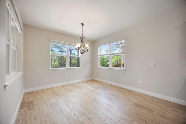 11680 Tapestry Ln, Venice, FL 34292 - spare room featuring healthy amount of natural light, a chandelier, and light wood-type flooring
