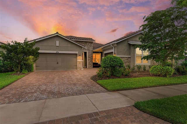 11680 Tapestry Ln, Venice, FL 34292 - view of front of property with stone siding, stucco siding, decorative driveway, a garage, and a tile roof